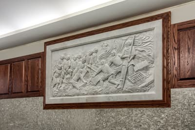 Carved marble relief artwork in Millennium Plaza lobby